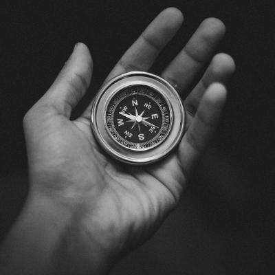 B&W photo of a hand holding a round compass