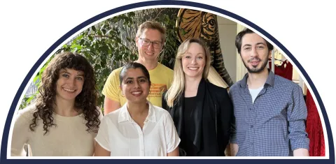Group of people smiling with trees in the background